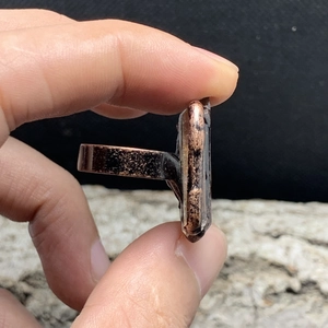 Detailed side view of vintage bronze ring with textured finish and raw quartz setting