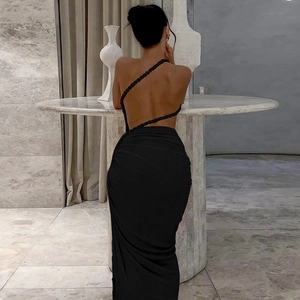 Detail of black backless dress showing rope strap design and draped open back silhouette