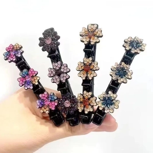 Dettaglio di quattro fermagli per capelli a becco d'anatra con fiori di strass colorati