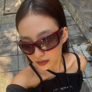 Y2K retro cat-eye sunglasses with thick dark red frames and embossed logo on the temple