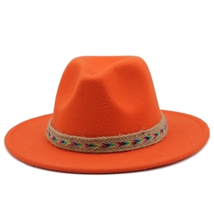 Detail of bright orange wool fedora hat with ethnic colorful woven band and wide brim