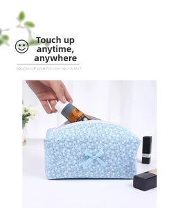 Close-up of floral makeup bag showing bow detail and hand placing skincare items inside