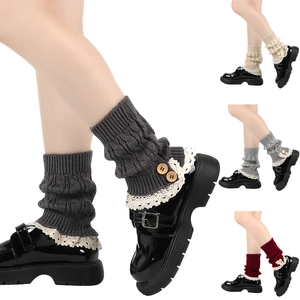 Detail of dark grey knit leg warmers with white lace trim and wooden buttons