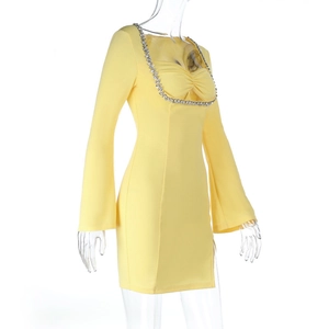 Détail de la robe courte jaune moulante avec encolure en strass et manches évasées
