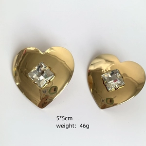 Macro shot of 5x5cm gold heart earrings with square crystals and 46g weight detail