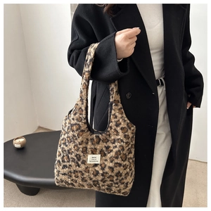 Detailed view of plush leopard print tote bag with soft texture and brand label
