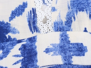 Détail du tissu tie-dye bleu avec dentelle blanche délicate et texture de maille fine