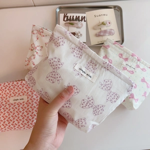 Detail of pink bow pattern makeup bag with 'simple wish' woven label and zipper