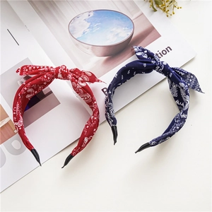Red and navy paisley pattern knotted headbands with fabric finish on a flat lay surface
