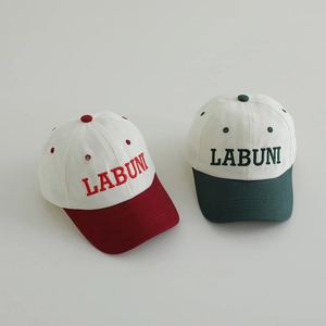 Close-up of LABUNI letter embroidery on red and green cotton kids baseball caps
