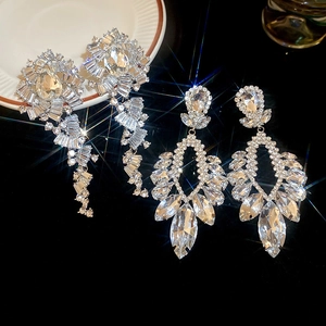 Gros plan de boucles d'oreilles pendantes en strass argenté avec effet scintillant étoilé
