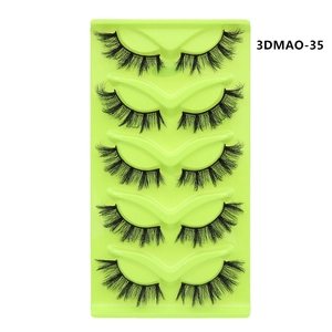 Detail view of 5 pairs of black fox-eye false eyelashes in a bright neon green tray