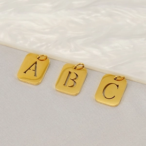 Golden hollow rectangular stainless steel letter pendants A, B, and C in a group display