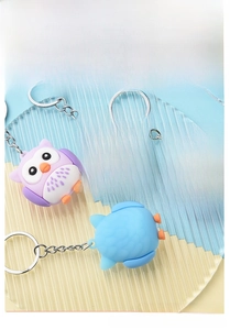 Detail of colorful owl keychains in purple, blue, and pink with soft PVC texture