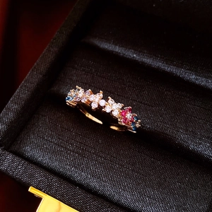Makroaufnahme des 18k vergoldeten Rings mit bunten Zirkonia auf schwarzer Seide