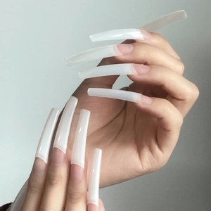 Detailed view of long semi-transparent natural white XXL square nail tips on hands