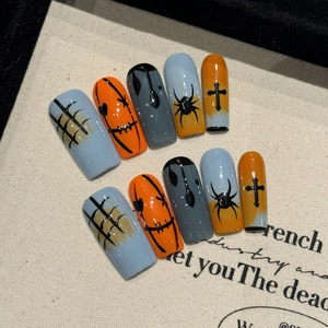 Halloween press-on nails featuring pumpkin faces, spiders, and gothic cross designs