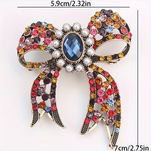 Vintage bow brooch with colorful rhinestones and blue gemstone center, size 5.9x7cm