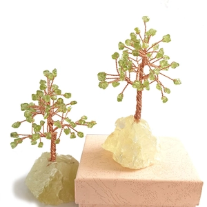 Green crystal tree of life with copper wire trunk and Citrine base on a pink gift box