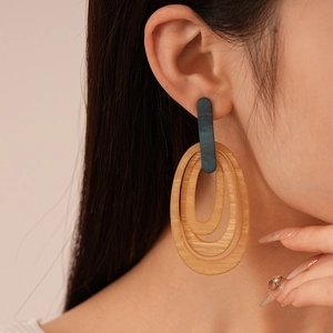 Retro multi-layered striped oval resin geometric earrings worn by model on side view