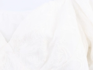Gros plan sur un tissu en dentelle blanche avec broderies florales sophistiquées