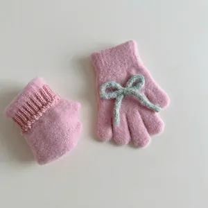 Pink plush knitted gloves for kids with soft blue bow decoration for winter warmth
