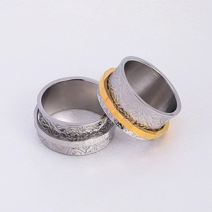 Detail of wide floral spinner rings showing intricate vintage engraving and two-tone finish