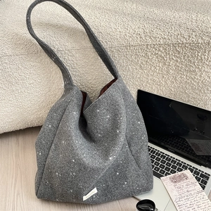 Dettaglio della borsa tote in feltro grigio scuro con motivo a stelle e etichetta laterale