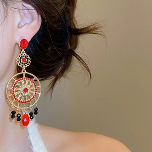 Gros plan sur des boucles d'oreilles vintage en or avec cristaux rouges et noirs