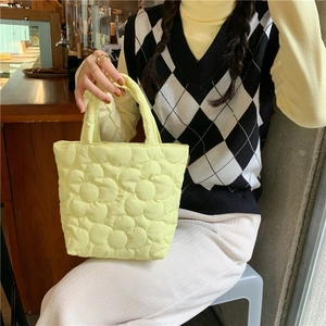 Detail of light yellow quilted tote bag with unique 3D floral embroidery pattern