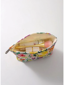 Floral canvas makeup bag with top zipper closure showing spacious open interior storage