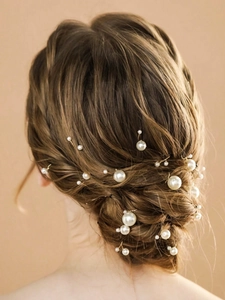 Detail of elegant handmade pearl hair clips for wedding hairstyles on a model