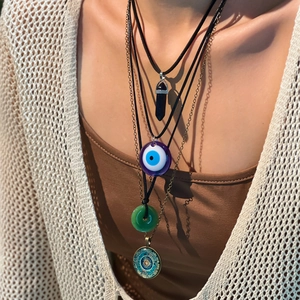 Detail of 4-piece boho necklace set with evil eye and mandala pendants on a model
