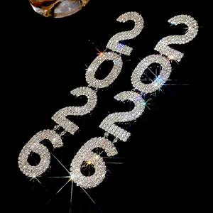 Sparkling silver drop earrings with 2026 number design and rhinestone tassels on black backdrop