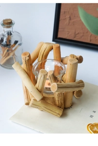 Detail of rustic driftwood candle holder with a clear glass insert and natural wood textures