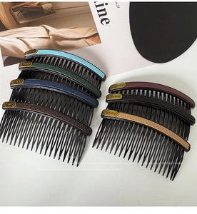 Detail of seven multi-colored hair combs with leather texture and golden Baby nameplate