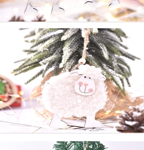Close-up of cute wool felt sheep ornament hanging on a warm lit Christmas tree branch