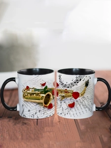 Detail of ceramic music mugs with golden saxophone design and music notes