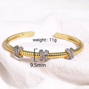 Vue macro du bracelet torsadé doré avec accents X sertis de cristaux, poids de 11g