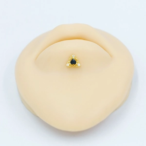 Gros plan détaillé du piercing de nombril doré avec pierre noire et cristaux de zircon
