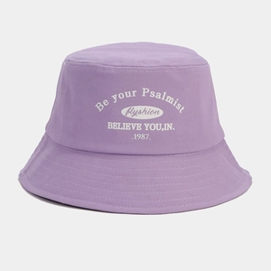 Close-up of purple canvas bucket hat featuring white embroidered artistic lettering detail
