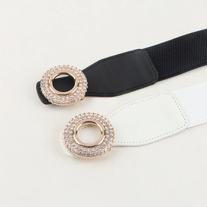 Women's elastic waist belts in black and white with decorative gold rhinestone buckles