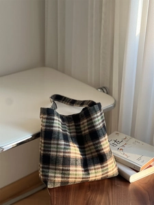 Gros plan du sac cabas en laine à carreaux rétro montrant les détails des coutures
