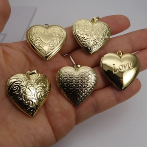 Five gold-plated heart-shaped locket pendants with intricate engraved floral patterns