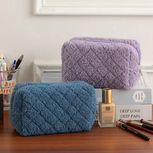Close-up of lilac and blue quilted fleece storage bags on a wooden desk with soft lighting