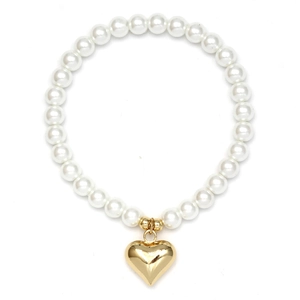 Detailed view of a white pearl bracelet featuring a minimalist golden heart pendant
