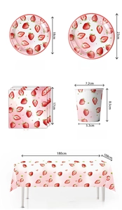 Detail view of strawberry party tableware set including plates, cups and tablecloth