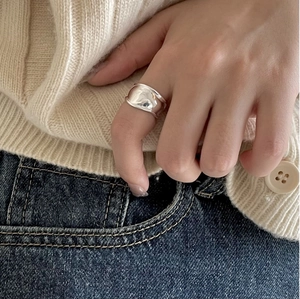 Close-up of wide irregular 925 sterling silver ring with liquid metal texture on hand