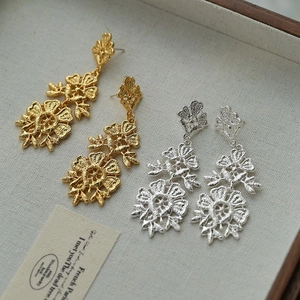 Vintage hollow flower tassel earrings in gold and silver finish on linen jewelry tray