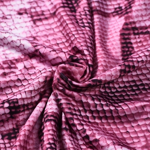 Vue détaillée du tissu à imprimé serpent rose avec un drapé fluide et soyeux